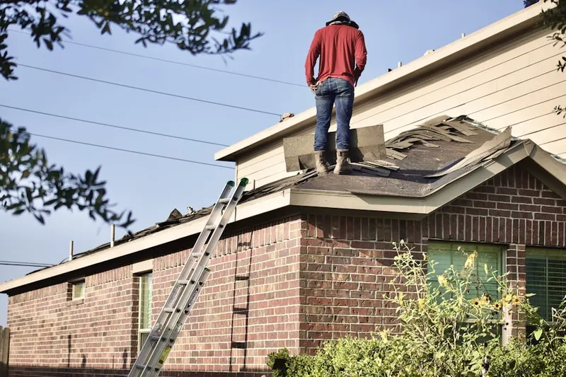 Professional roofer working on a residential roof in Dorchester Manor